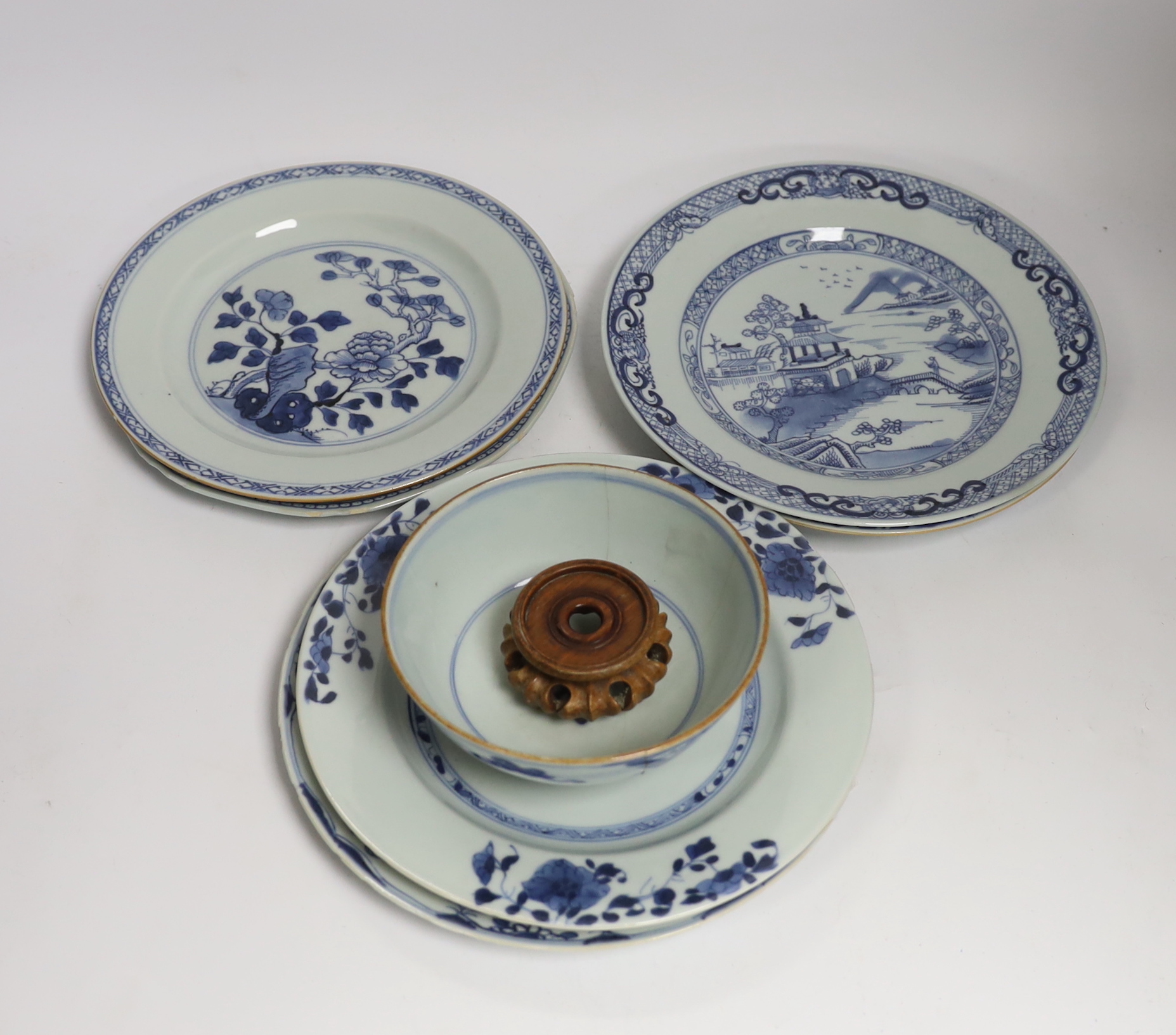 Six Chinese blue and white plates, 18th century and a Kangxi blue and white bowl and wood stand